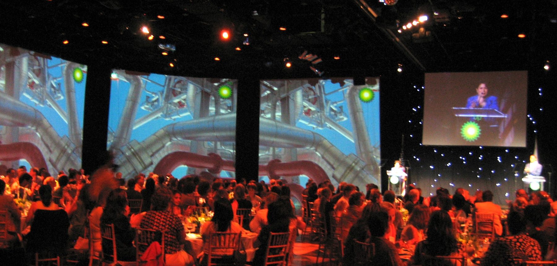 Universal Studios Hollywood Globe Theatre live event with projection screens, audience seating, podiums, and stage lighting